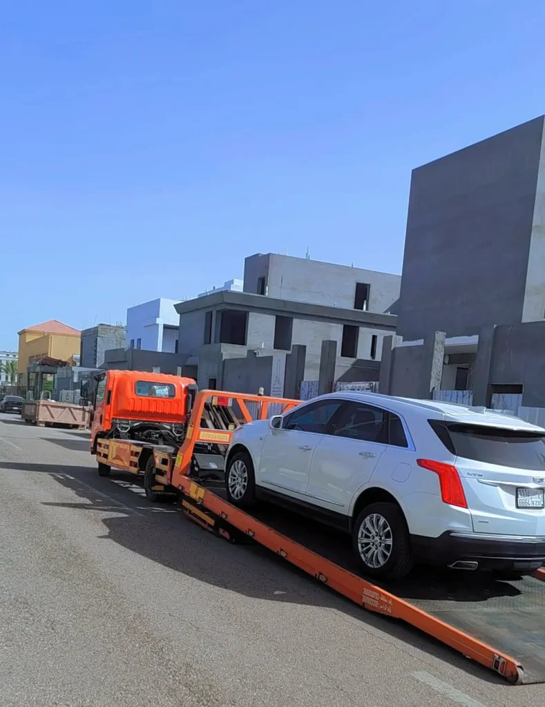 MIQ Towing truck loading a white car for recovery service.